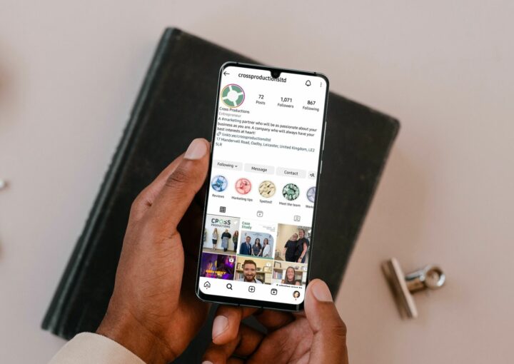 A guide to instagram marketing: hands holding a mobile phone which is open to a company page on Instagram