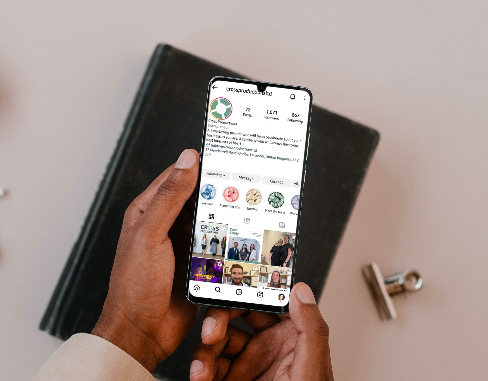 A guide to instagram marketing: hands holding a mobile phone which is open to a company page on Instagram