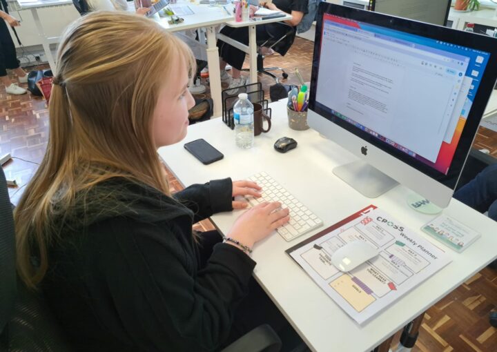 work experience as a marketing strategy: Student Alice Kotulecki on work experience sits at a white desk working on a Mac