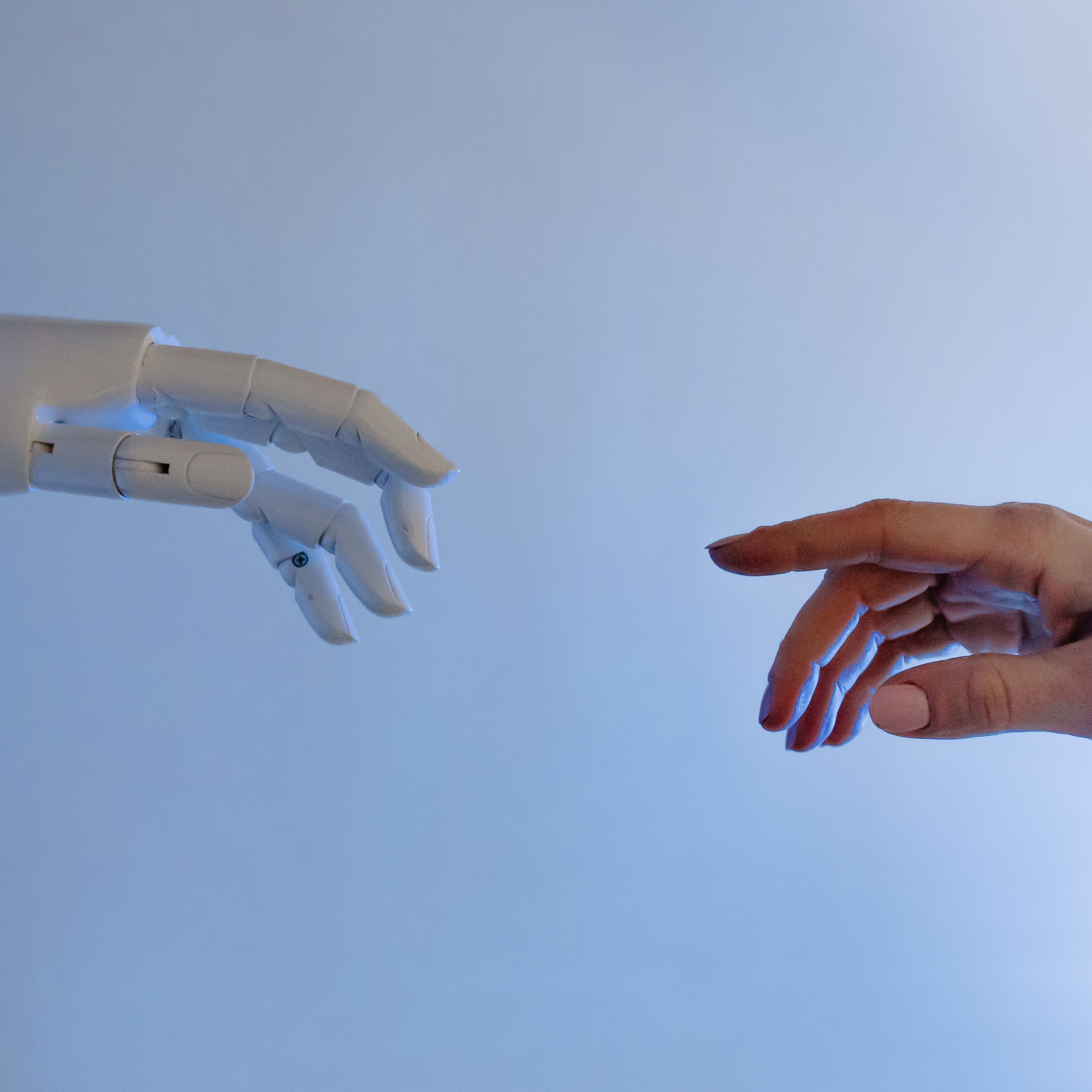 human hand moving towards robotic hand